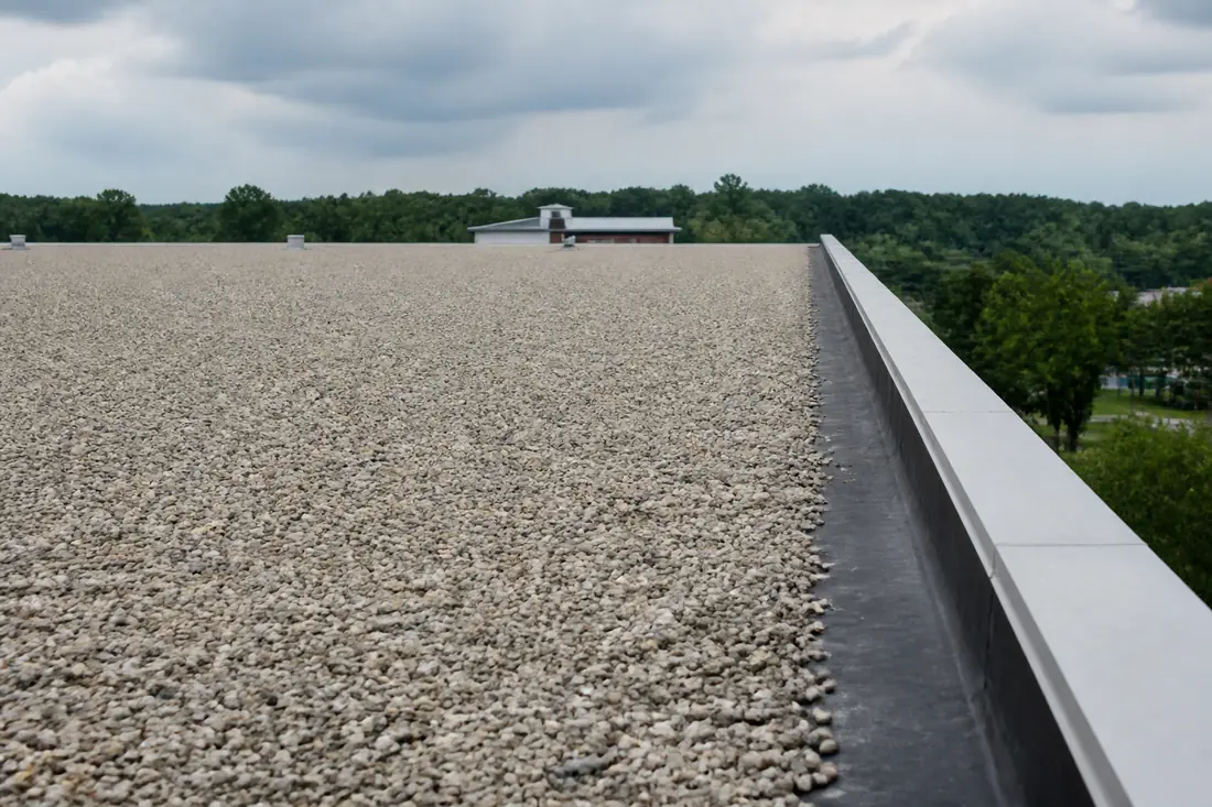 Rounded stone ballast spread over a single-ply membrane roof