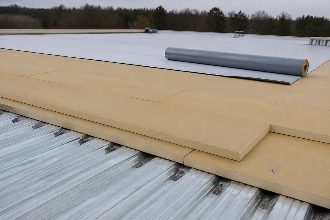 Two staggered layers of insulation board above a roof deck